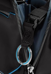 Interieur van zwarte leren tas met een blauw gevoerd vak, zilveren rits met een metalen ronde clip en zwart banddetail.