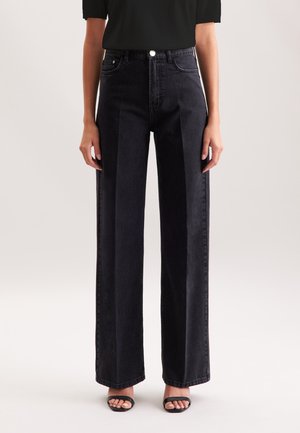 Jeans en denim noir taille haute et jambes larges avec poches avant et fermeture à bouton ; possède une texture lisse et des ourlets droits.