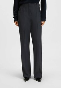 Graue gestreifte Hose mit geradem Schnitt und Fronttaschen; strukturierter Stoff und Knopfverschluss an der Taille.