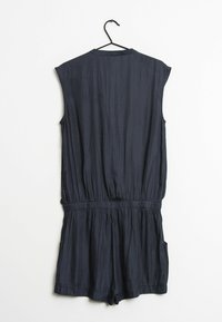 Tmavě námořnický overal bez rukávů s texturovanou tkaninou, elastickým páskem a bočními kapsami, vykazující uvolněný střih a krátké nohavice.