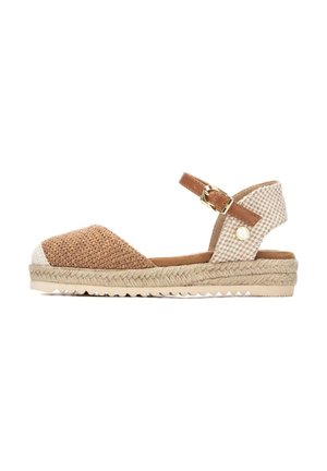 Sandalia espadrille tejida marrón con puntera blanca, correa de tobillo en tono canela con hebilla y suela plataforma de yute. Detalle de tablero de ajedrez en el talón.