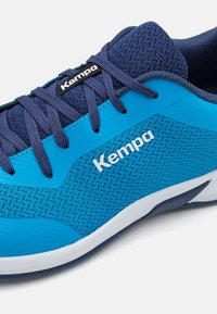 Scarpa atletica blu con tomaia in mesh e sintetico, con lacci blu navy e branding. Notevoli motivi testurizzati e design della suola a contrasto.