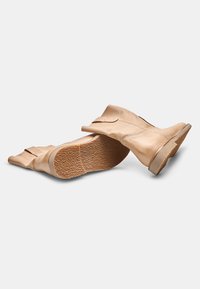 Béžové kožené kotníkové boty s hladkým povrchem, s kulatou špičkou, nízkým vrstveným podpatkem a textured gumovou podrážkou.