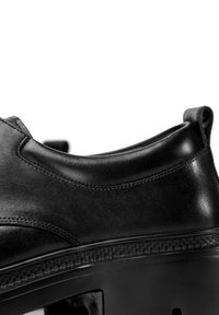 Černá kožená bota s hladkým povrchem, zaobleným límcem a silnou, vzorovanou podrážkou. Elegatní design s minimem švů.