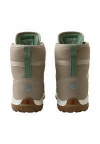 Zapatos de caña alta en beige con acentos verdes, fabricados con textil y goma. Presentan una suela texturizada y un interior acolchado para mayor comodidad.