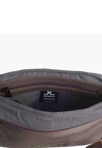 Innenansicht einer grauen Stofftasche mit einem Reißverschluss, die ein Etikett mit der Aufschrift "Margelisch SWISS DESIGN" und einer leicht strukturierten Oberfläche aufweist.