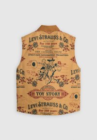 Bež prsluk s Toy Story motivom, s ilustracijama, dekorativnim tekstom i urezanim cvjetovima u tamnocrvenim i plavim tonovima.