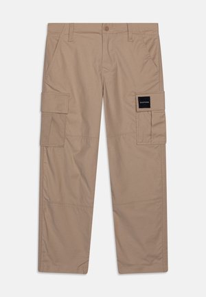 Khaki spodnie cargo wykonane z mieszanki bawełny. Posiadają wiele kieszeni, zapięcie na guziki oraz firmową naszywkę z boku. Prostota nogawek.