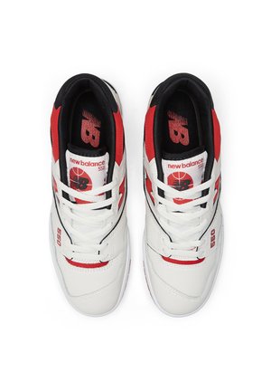 Par hvide, røde og sorte New Balance 550 sneakers med rød "NB" logo og "new balance 550" tekst på tungen, set oppefra.