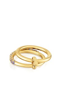 Dos anillos de oro entrelazados, uno con pequeñas gemas púrpuras a lo largo de la banda, el otro con un pequeño detalle en forma de flor.