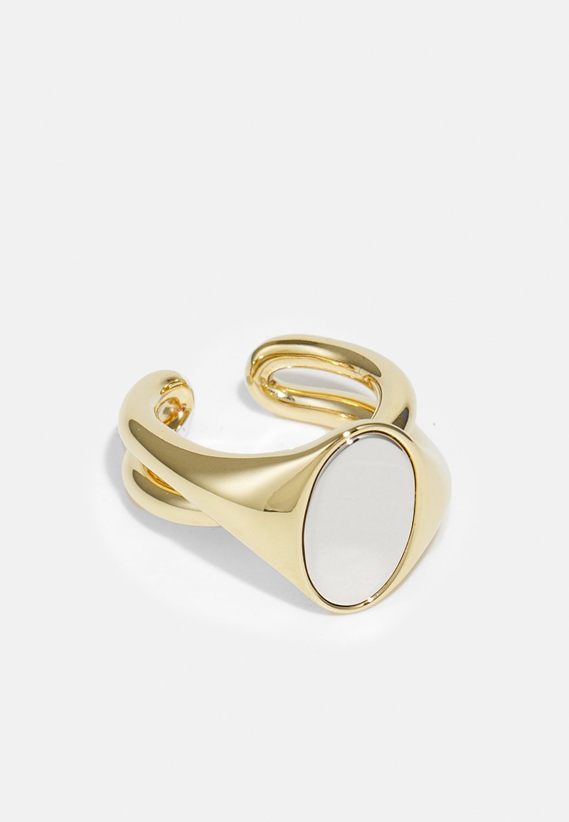 Goldfarbener Armreif mit einem glatten, ovalen Mittelstück und offenem Design; reflektierende Oberfläche und polierte Ausführung.