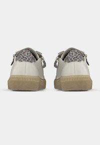 Beežid tennised tekstuurse kummist tallaga, tagaküljel leopardimustriga aktsent ja voolujooneline disain minimaalse riistvaraga.