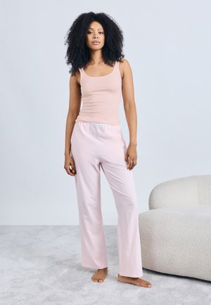 Ανοιχτό ροζ αμάνικο τοπ σε συνδυασμό με φαρδιά, ταιριαστά ροζ παντελόνια πιτζάμας. Απαλό ύφασμα, απλός σχεδιασμός και ελαστική μέση για άνεση.