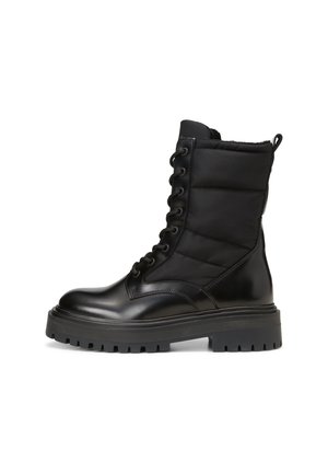 Botte de combat noire avec un bout en cuir brillant, tige en nylon matelassé, semelle en caoutchouc robuste avec des semelles profondes, et fermeture à lacets noirs.