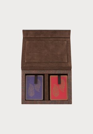 Brown suede case holding two decks of playing cards with purple and red backs, each featuring a gold paisley design and black pull tabs.