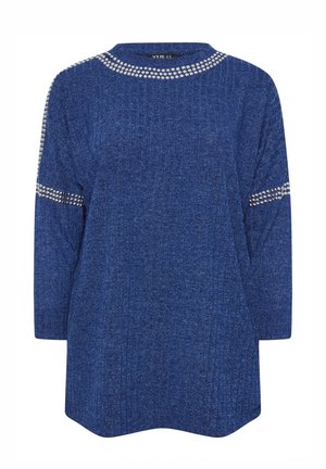 Blå strikket sweater med ribbet tekstur, rund halsudskæring, trekvartslange ærmer og udsmykket med sølvnitter langs skuldrene.