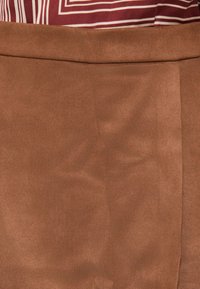 Brun sued skjørt med en jevn tekstur, med en sømløs midjebånd og en rett snittdesign som viser subtil drapering.