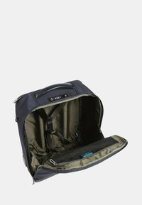 Zaino blu scuro con esterno in tessuto morbido, ampio interno in tessuto verde, spallacci regolabili e scomparto con zip.