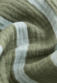 Tela de algodón en rayas verdes apagadas y blancas, con un tejido suave y texturizado. El material parece ligero y con caída.