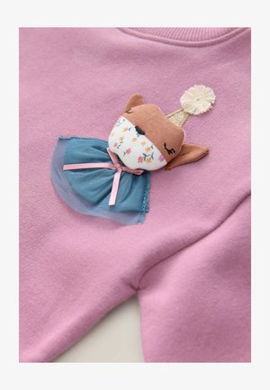 Roza pulover z aplikacijo iz blaga v obliki lisice, modra tila krila in zlat krono, podrobno okrašena s cvetličnimi vzorci na obrazu.