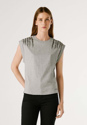 Camiseta gris de manga corta con acentos texturizados en los hombros en un diseño de cuentas. La tela parece suave, con un ajuste holgado y cuello redondo.