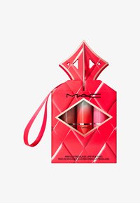 Rød diamantmønstrede eske med gullaccenter og båndhåndtak, som inneholder tre mini leppegelskinnrør i gradientfarger av brunt, rødt og rosa.