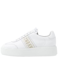 Bílé kožené platformové tenisky s tlustou podrážkou, béžový pruh po straně s textem "NBNBK" a prošívané detaily podél okrajů.