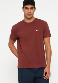 Μπορντό κοντομάνικο μπλουζάκι από βαμβάκι με στρογγυλή λαιμόκοψη και μικρή λογότυπη ετικέτα στο στήθος. Στενή εφαρμογή, λεία υφή.