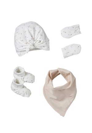 Weißer Babyhut, Fäustlinge, Booties mit kleinem Blumenmuster und beiger dreieckiger Lätzchen auf weißem Hintergrund arrangiert.