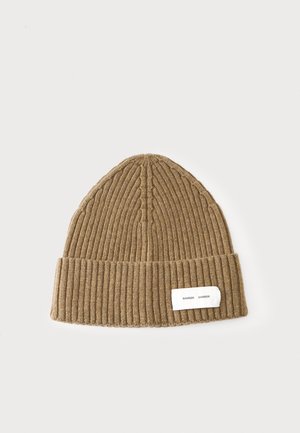 Braune gerippte Strickmütze mit umgeschlagenem Bündchen und weißem rechteckigem Etikett mit der Aufschrift "Samsøe Samsøe" auf schlicht hellem Hintergrund.