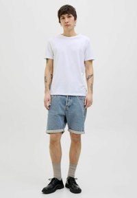 White cotton t-shirt, light blue denim shorts with rolled hems, grey socks, and black leather shoes. Simple, casual outfit.