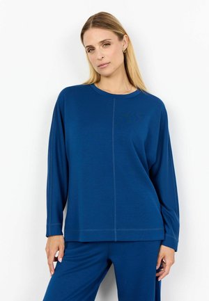 Blauwe langesleeve top van zachte stof, met een relaxed fit, ronde halslijn en zichtbare naden aan de voorkant.