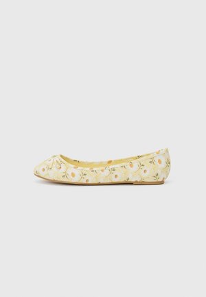 Gelbe Blumen-Ballerinas mit einem strukturierten Muster, Schleifendetail an der Zehe und kleinem Absatz. Weicher Stoff und gepolsterter Innenraum.