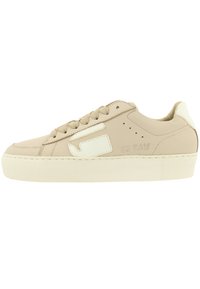 Beige sneakers met een gladde stoffen bovenkant, witte accenten, een dikke platformzool en ronde veters. Beschikt over logodetails aan de zijkant.