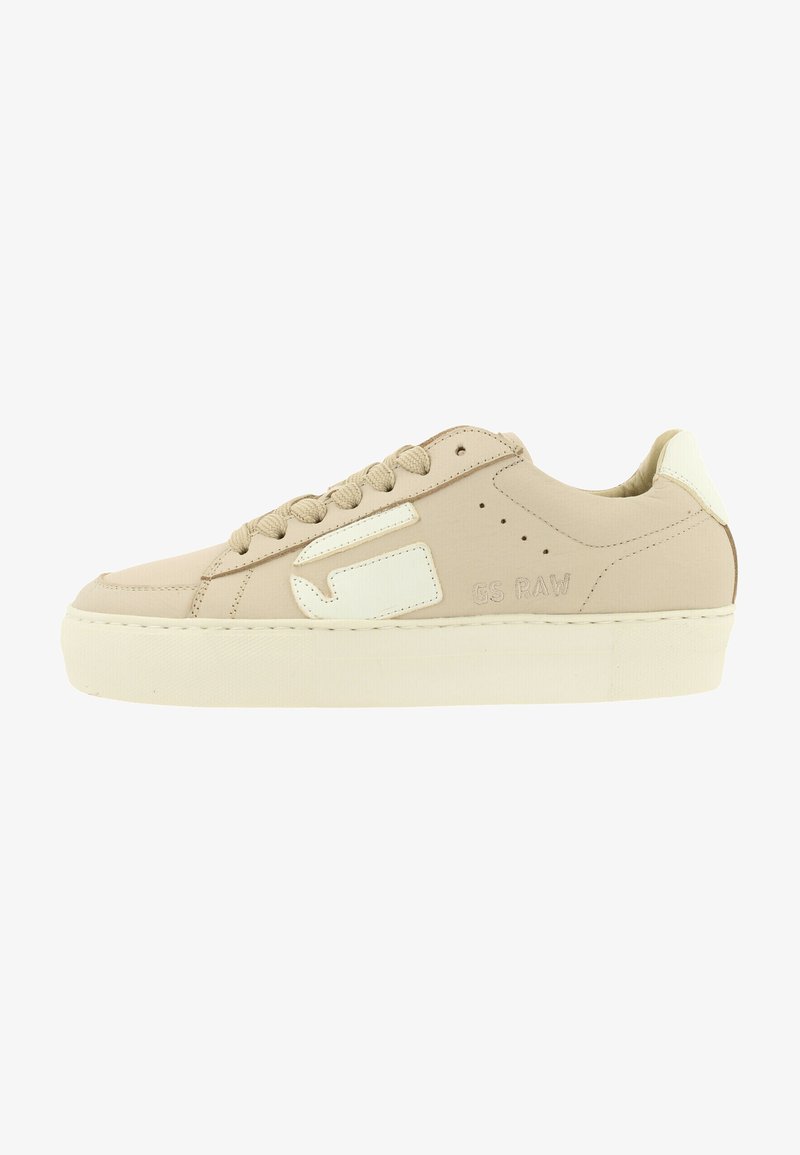 Beige sneakers met een gladde stoffen bovenkant, witte accenten, een dikke platformzool en ronde veters. Beschikt over logodetails aan de zijkant.