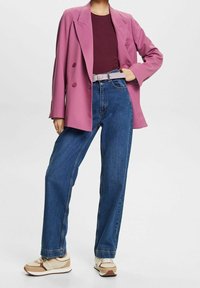 Vaaleanpunainen kaksirivinen bleiseri, viininpunainen ribbineulospaita, korkeat siniset farkut ja beige tennarit ruskeilla yksityiskohdilla; tasainen tekstuuri kauttaaltaan.