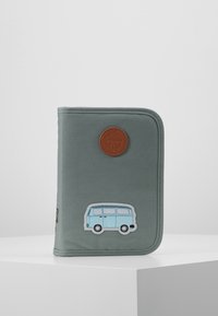 Pochette zippée en tissu vert ornée d'un patch circulaire marron et d'une application de vanette bleue sur le devant. Texture lisse avec des coutures discrètes.