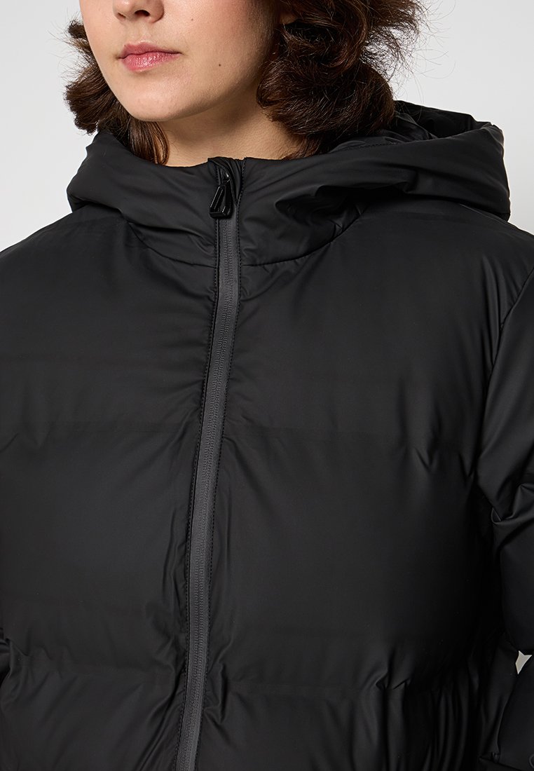 Veste à capuche noire avec une texture lisse et brillante. Dotée d'une fermeture éclair à l'avant, d'un design matelassé et d'une capuche ajustée.