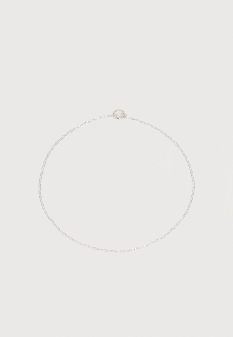Λεπτό ασημένιο κολιέ με μικρούς οβάλ κρίκους και στρογγυλό ελατήριο κούμπωμα σε απλό λευκό φόντο.