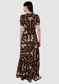 Maxi-jurk van zwarte stof versierd met bloemen- en geometrische patronen in perzik, crème en goud. Inclusief geschulpte zoom en puffmouwen.