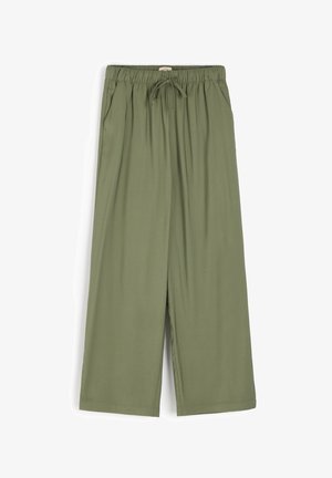 Zielonooliwkowe, szerokie spodnie wykonane z miękkiego materiału; mają elastyczny pas ze sznurkiem i boczne kieszenie. Gładka tekstura bez wzorów.