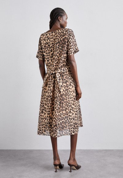 Robe midi à imprimé léopard en tissu transparent, avec des manches courtes et une ceinture nouée à la taille. Motif marron et noir, coupe décontractée.