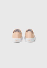 Rosa kanvas sneakers med hvite gummisåler, med et enkelt design og en liten logo-patch på hælen. Rund tå og flate lisser.