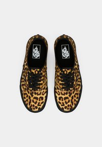 Leopardprint canvas sneakers met zwarte veters, een zwarte rubberen zool en het Vans-logo op de tong. Glad textuur en een ronde neusontwerp.