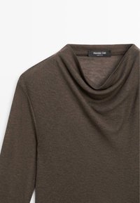 Rollkragenoberteil in Dunkelbraun aus weichem Stoff. Mit langen Ärmeln und einem drapierten Ausschnitt, dezent strukturiert und mit sauberem Abschluss.