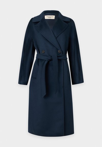 Manteau long bleu marine avec larges revers, boutonnière croisée, ceinture à la taille et poches latérales, présenté sur un fond uni.