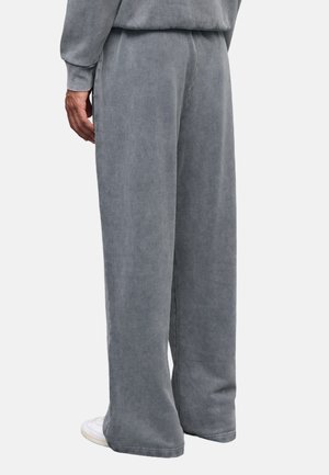 Grijze, wijde sweatpants gemaakt van zachte stof met een textuurafwerking. Beschikt over een elastische tailleband en subtiele stikdetails.