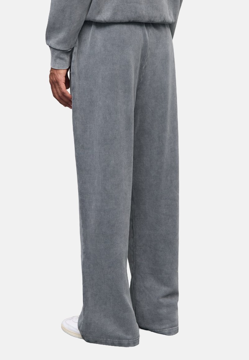 Grijze, wijde sweatpants gemaakt van zachte stof met een textuurafwerking. Beschikt over een elastische tailleband en subtiele stikdetails.
