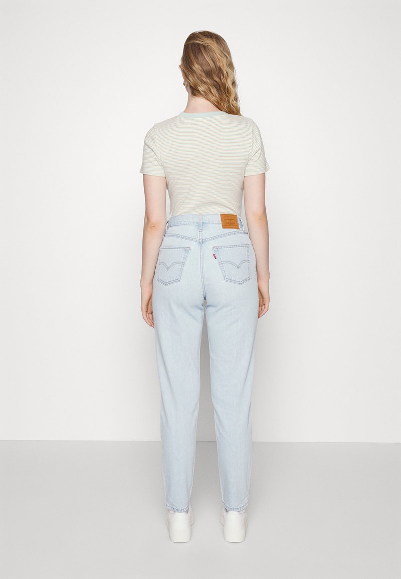 Helle blaue hochtaillierte Jeans mit geradem Bein, ausgestattet mit einem Leder-Logopatch auf der Rückseite und einer dezenten, verblassten Textur.