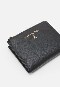 Portafoglio nero in pelle con finitura testurizzata, logo in tonalità oro e chiusura con zip. Forma quadrata con angoli arrotondati.